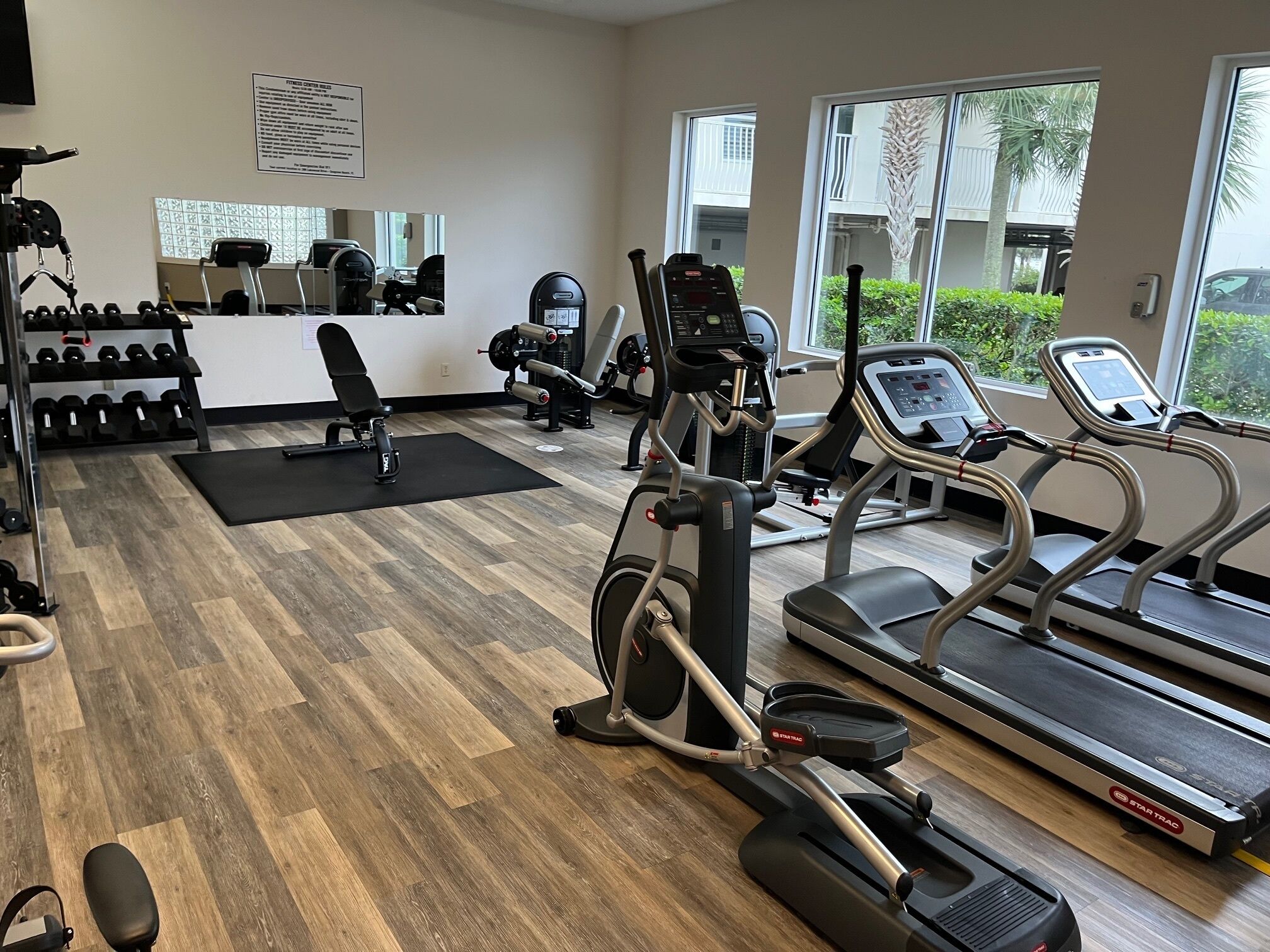 A gym with treadmills, elliptical machines, and free weights.