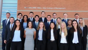 Un groupe de personnes se tient devant le bâtiment McClelland Hall, sur le campus de l’université de l’Arizona.