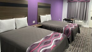 A hotel room with two beds, a desk, and a window with curtains. - Palace Inn Crosby (Crosby)