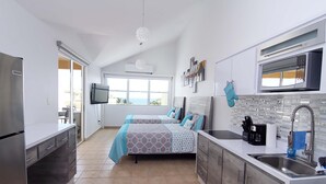 A modern kitchen with a microwave, sink, and a large window. - Beachfront Modern Loft with Large Private Terrace (Isabela)