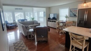 A spacious living area with a sofa, TV, and dining area. - Memory Lane with Community Pool! (Laconia)