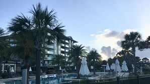 A resort with a swimming pool, palm trees, and a multi-story building. - OCEAN FRONT, PRIVATE BEACH Luxury Suite with Balcony sleeping 8 adults (Hilton Head Island)
