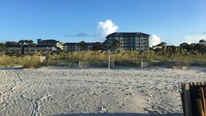 A beach with a hotel in the background. - OCEAN FRONT, PRIVATE BEACH Luxury Suite with Balcony sleeping 8 adults (Hilton Head Island)