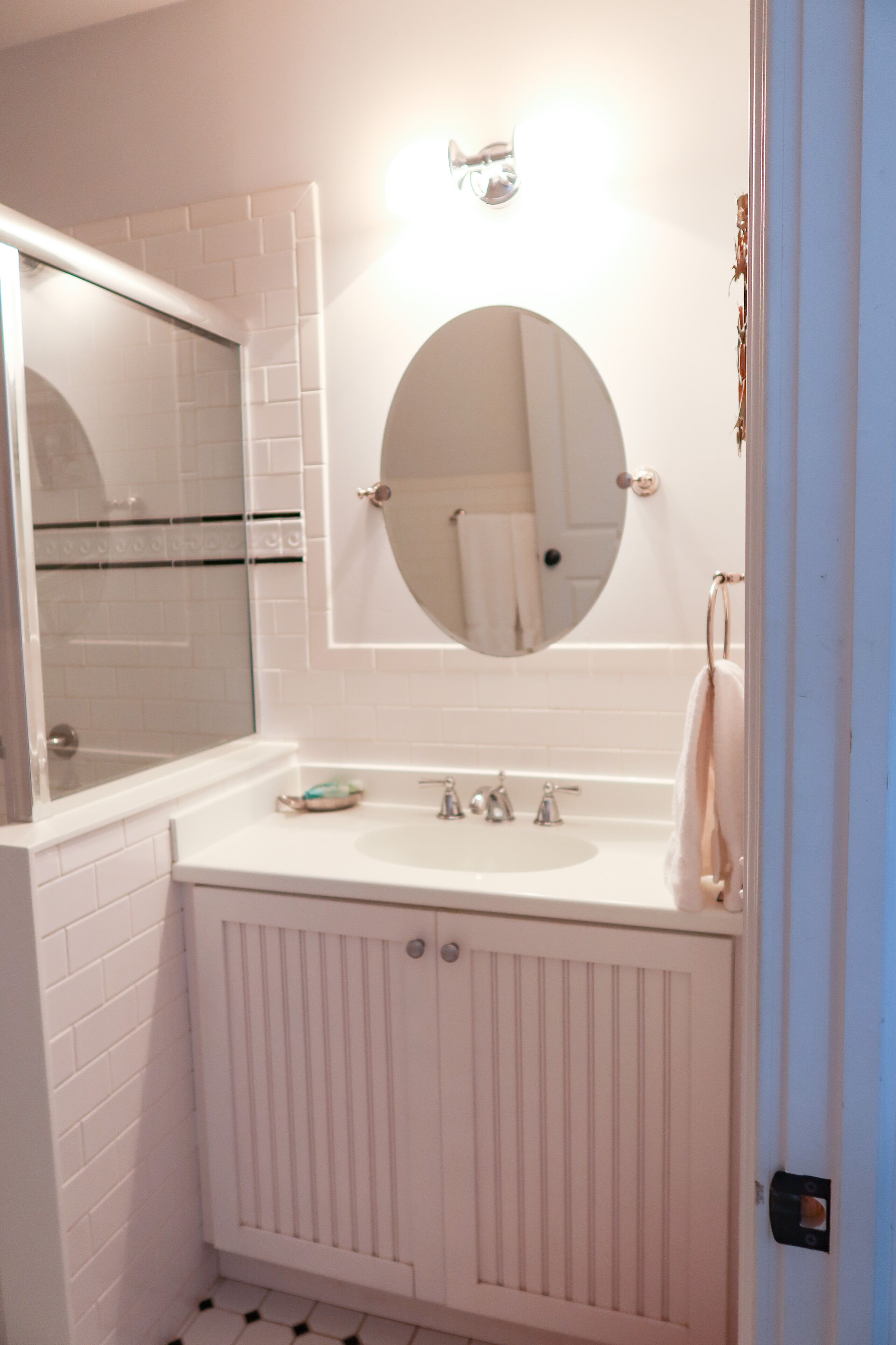 A bathroom with a white sink, a mirror, and a towel rack.