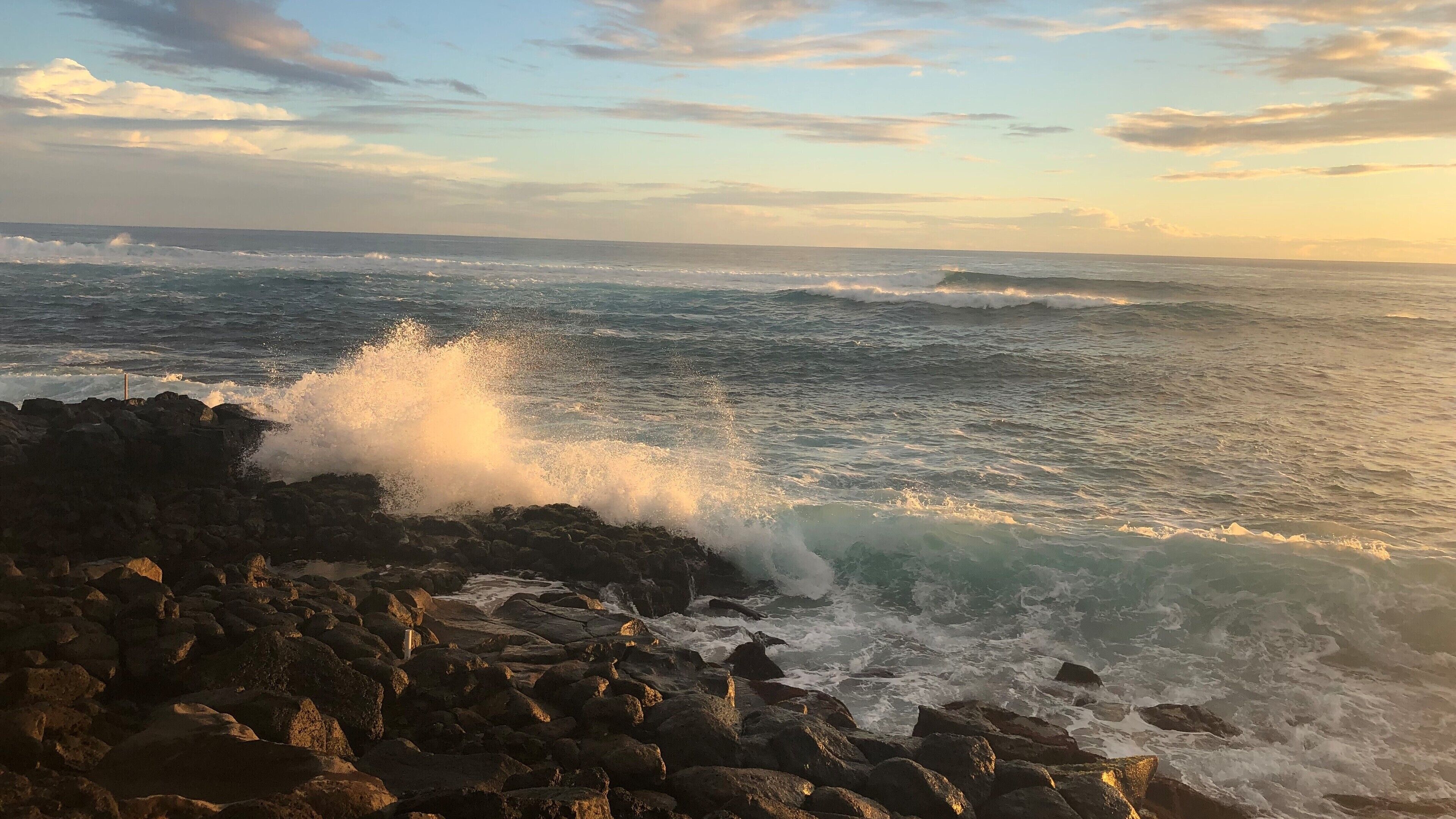A rocky shoreline with waves crashing against the rocks.