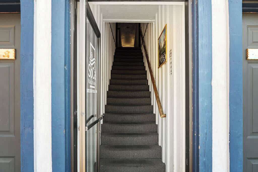 Eine Treppe führt zu einer Tür, an der ein Schild mit der Aufschrift 'Soci' befestigt ist.