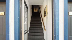Eine Treppe führt zu einer Tür, an der ein Schild mit der Aufschrift 'Soci' befestigt ist.