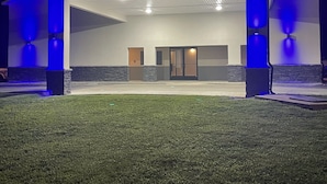 A building with a covered entrance, stone accents, and blue lighting.