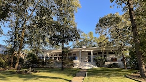 A two-story house with a covered porch, a stone staircase leading to the front door, and a well-maintained lawn. - Home on Hot Springs beautiful Lake Hamilton. TWO MASTER SUITES!!  (Hot Springs)
