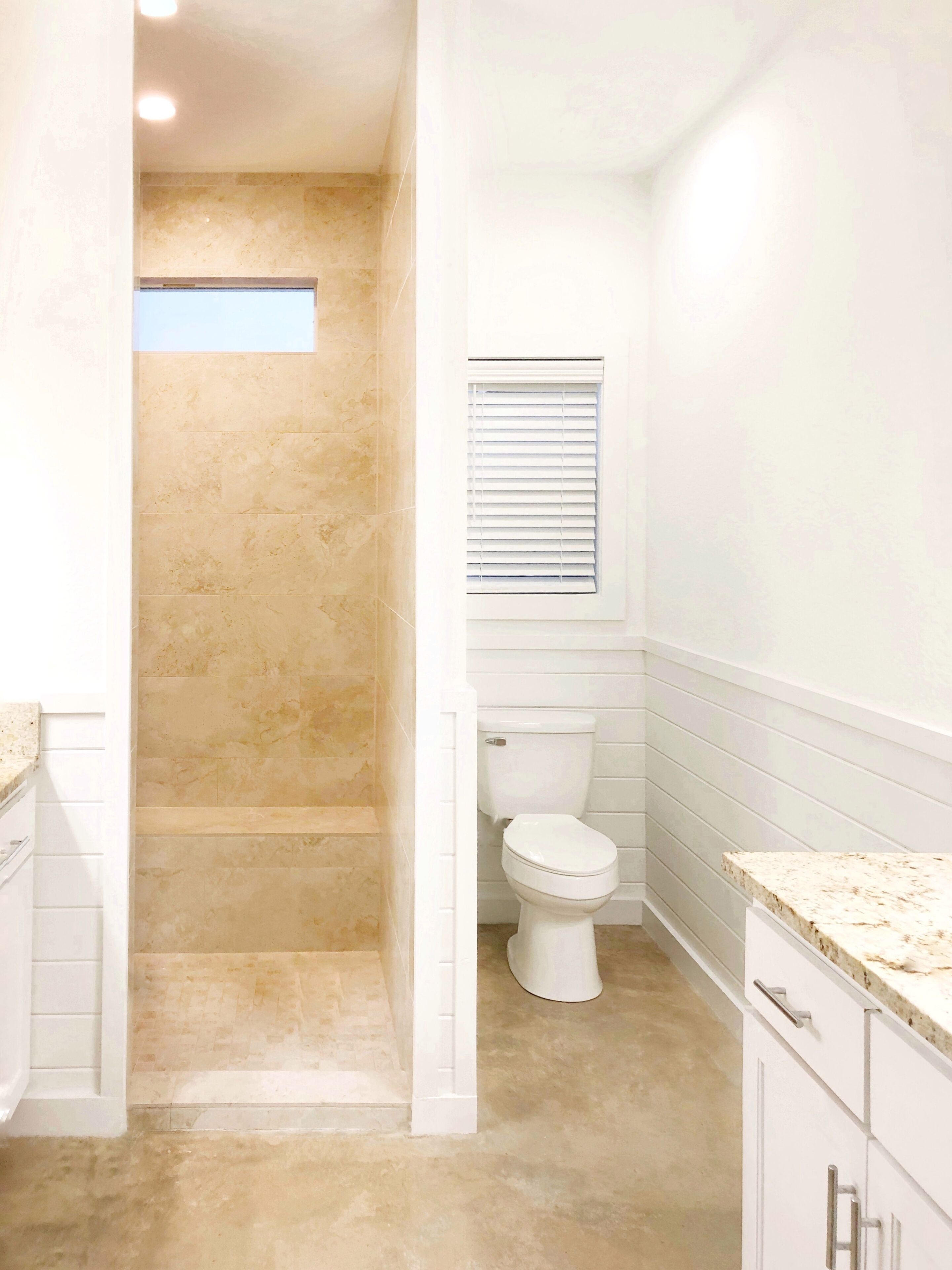 A bathroom with a shower, toilet, and vanity.