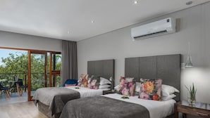 A modern hotel room with two beds, a balcony, and an air conditioning unit.