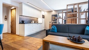Un espace de vie moderne comprenant une cuisine, un canapé et une table basse.