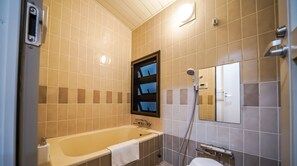Un baño con bañera, ducha y retrete.