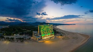 Un hotel de varios pisos con vista a la playa, situado cerca del agua.