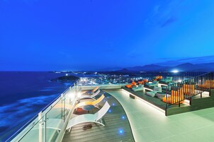 Una terraza con mobiliario exterior y vistas al mar.