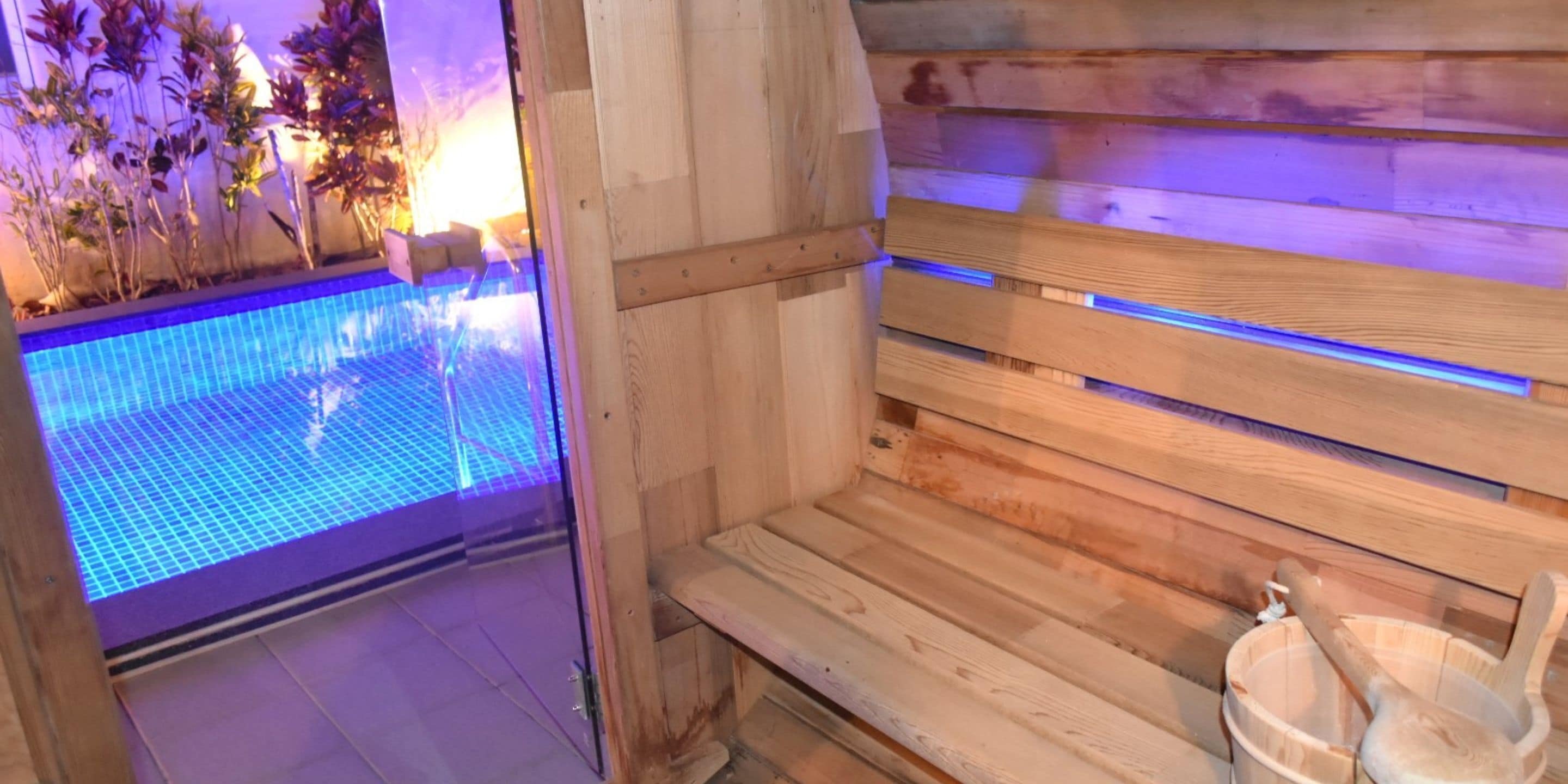 A wooden sauna with a bench and a bucket.