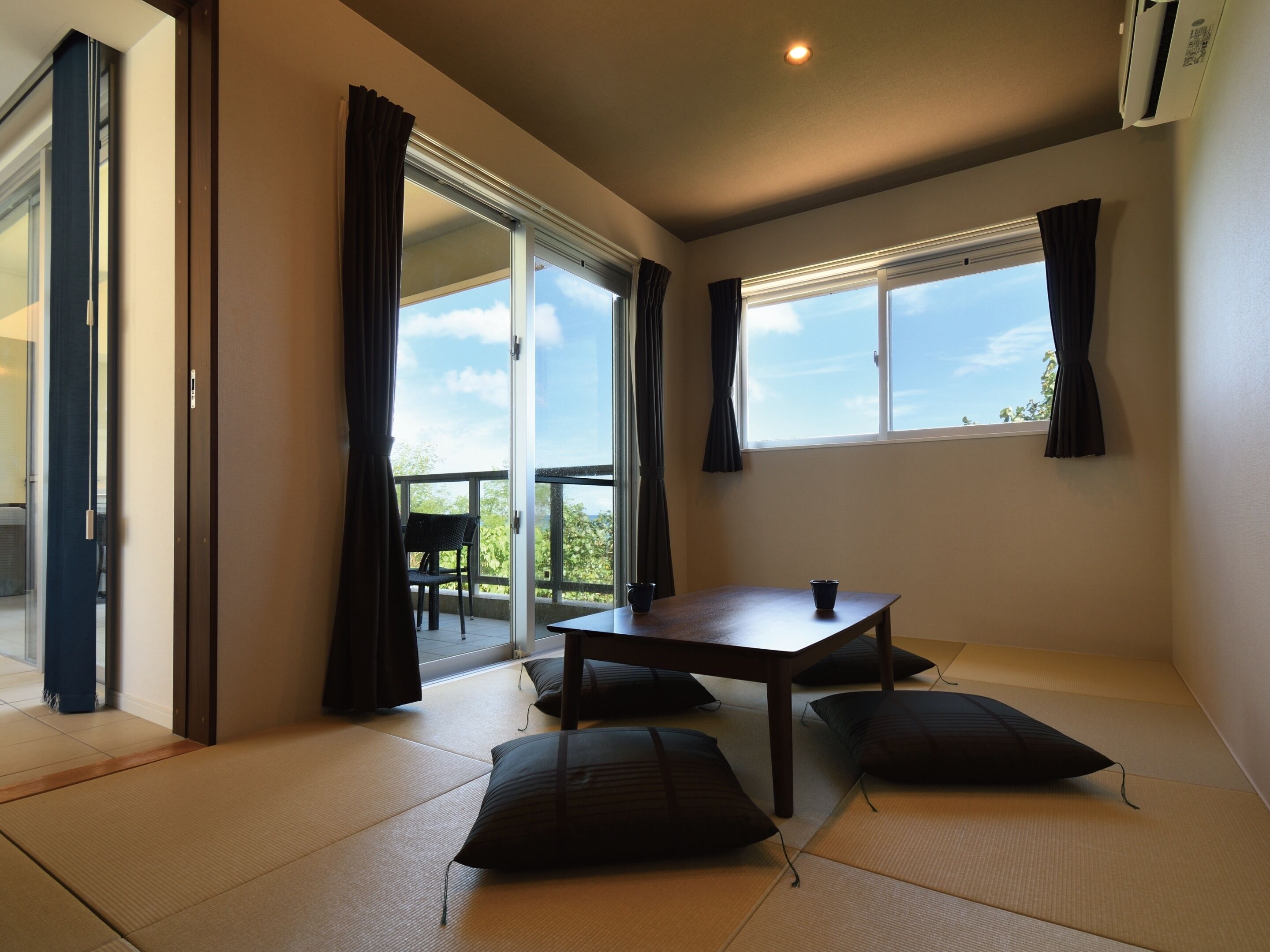 Una habitación con suelo de tatami, una mesa y cojines.