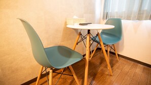 A small room with a wooden floor, a white table, two teal chairs, and a white sofa. - Vail sta. Takenotsuka (Tokyo)