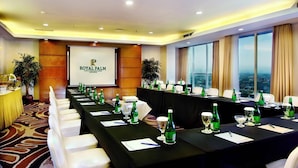 Un salón de conferencias en el Hotel Royal Palm con una larga mesa dispuesta para reuniones, ventanas amplias y vistas a la ciudad.