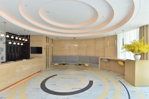 A modern reception area with a circular seating arrangement, a reception desk, and a decorative ceiling. - Jinjiang Inn Select (Sanyawan Jinjiling) (Sanya)