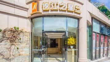 A hotel entrance with a glass door and a sign above it.