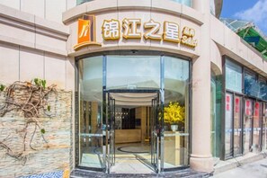 A hotel entrance with a glass door and a sign above it.
