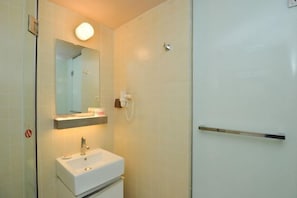 Ein Badezimmer mit Waschbecken, Spiegel und Duschbereich.