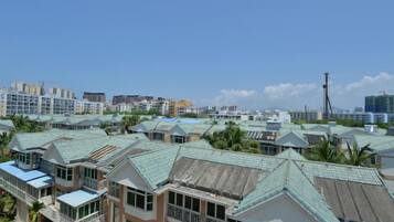 A coastal hotel with multiple buildings, each featuring a green roof and balconies.