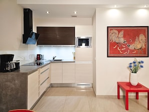 A modern kitchen with a built-in microwave, a coffee maker, and a sink.