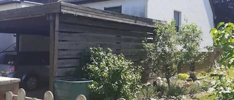 Une maison avec un toit en pente, une véranda et une clôture en bois.