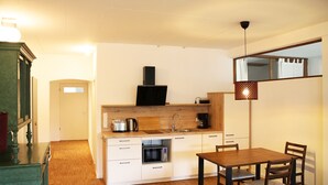 A compact kitchen with a microwave, toaster, and sink. There is a dining area with a table and chairs. - Vacation apartment Obere Stadt in the center of Weilheim (Weilheim in Oberbayern)
