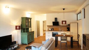 A compact living space with a sofa, TV, kitchenette, and dining area. - Vacation apartment Obere Stadt in the center of Weilheim (Weilheim in Oberbayern)