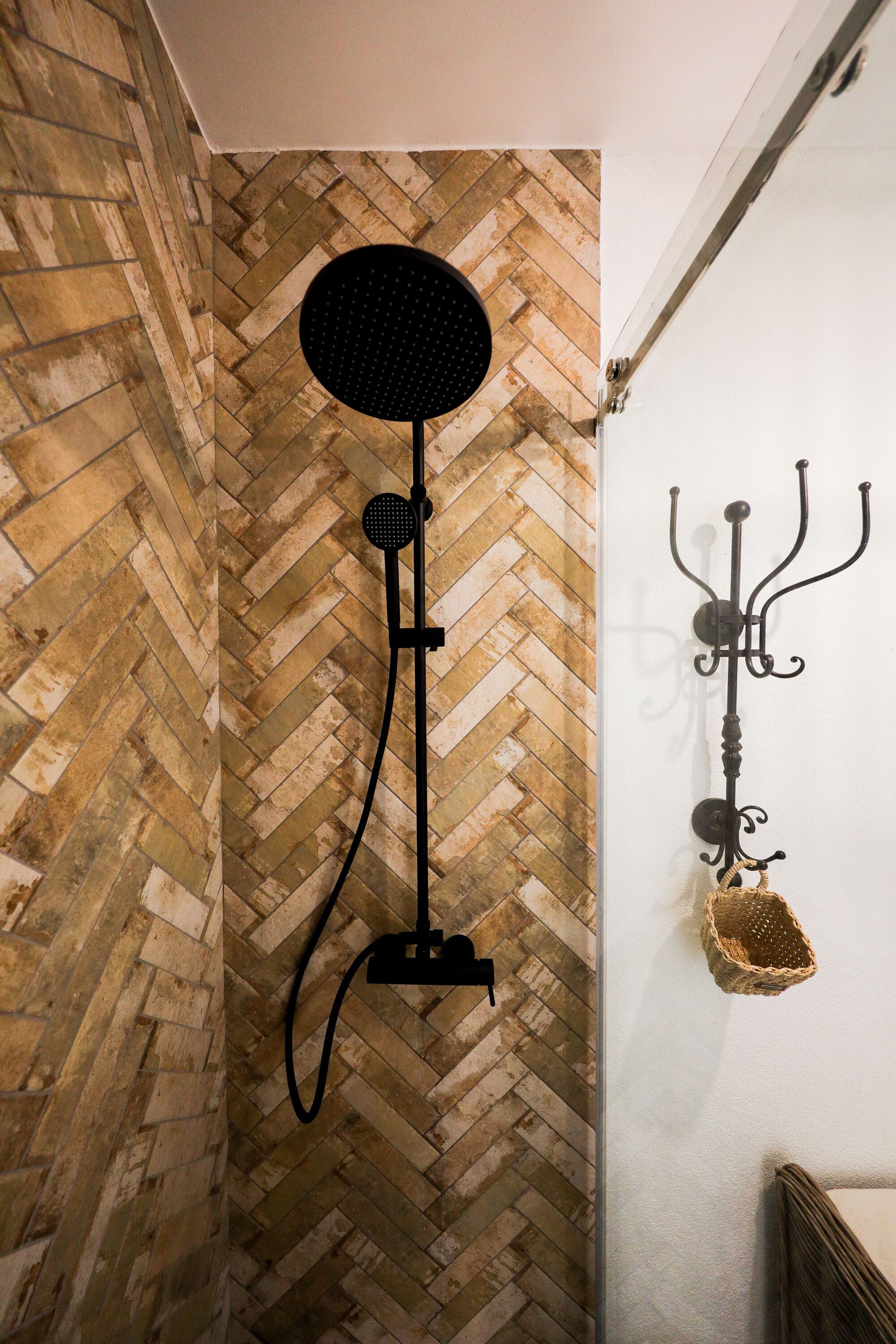 Una habitación con pared de madera en patrón de espiga y una lámpara de pie negra.