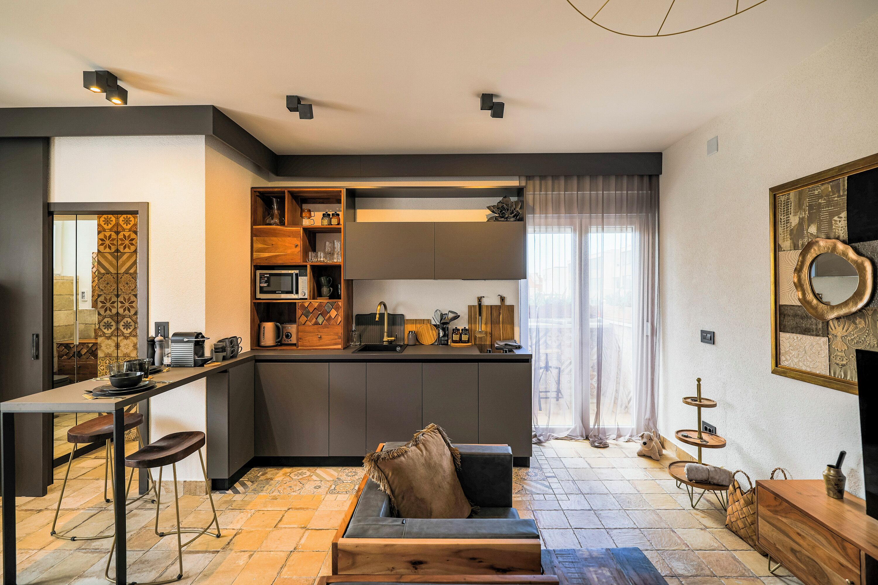 A compact living space with a kitchenette, a sofa, and a dining area.