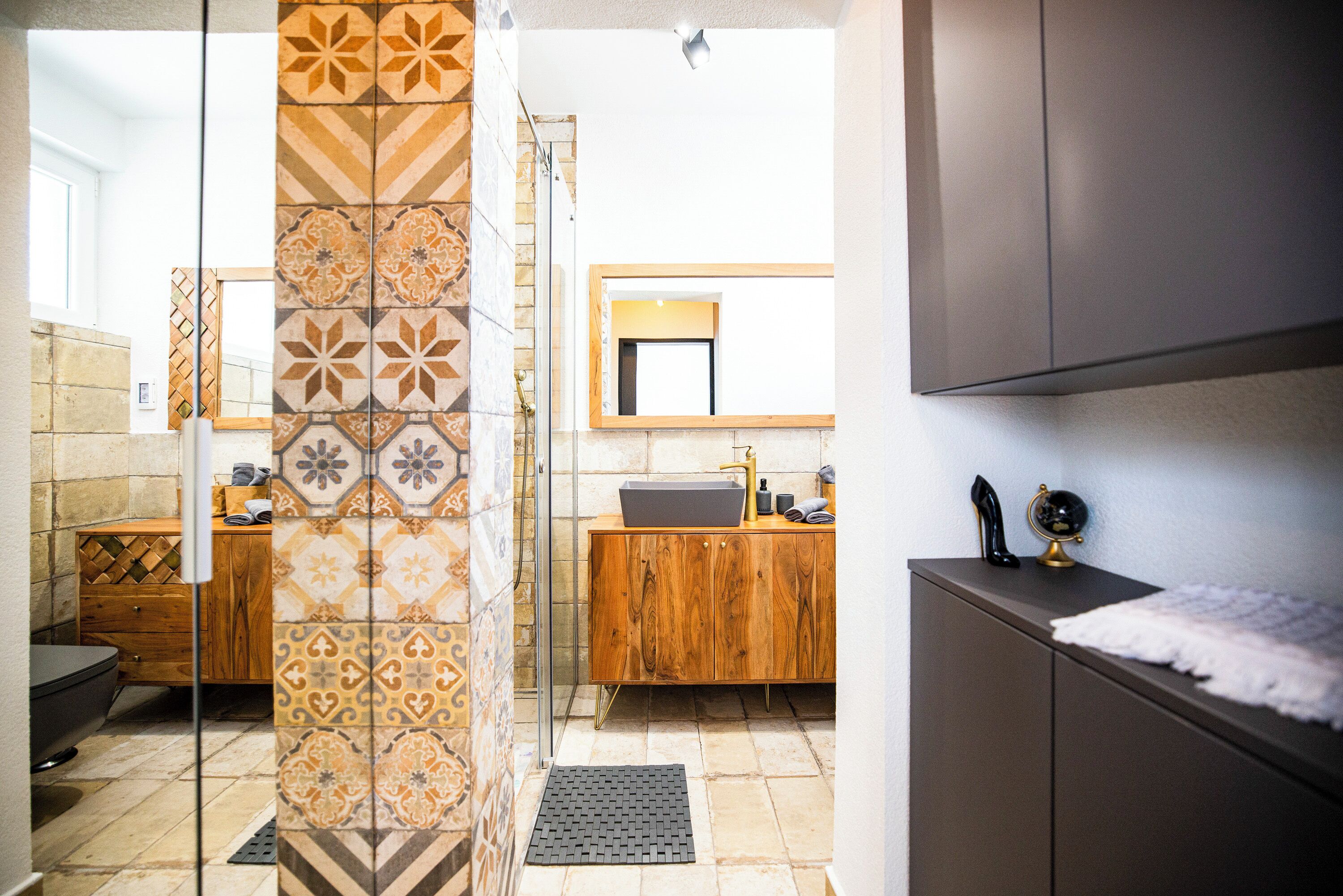 Een moderne badkamer met douche, wastafel en badkamermeubel.