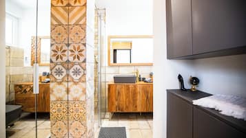 Een moderne badkamer met douche, wastafel en badkamermeubel.