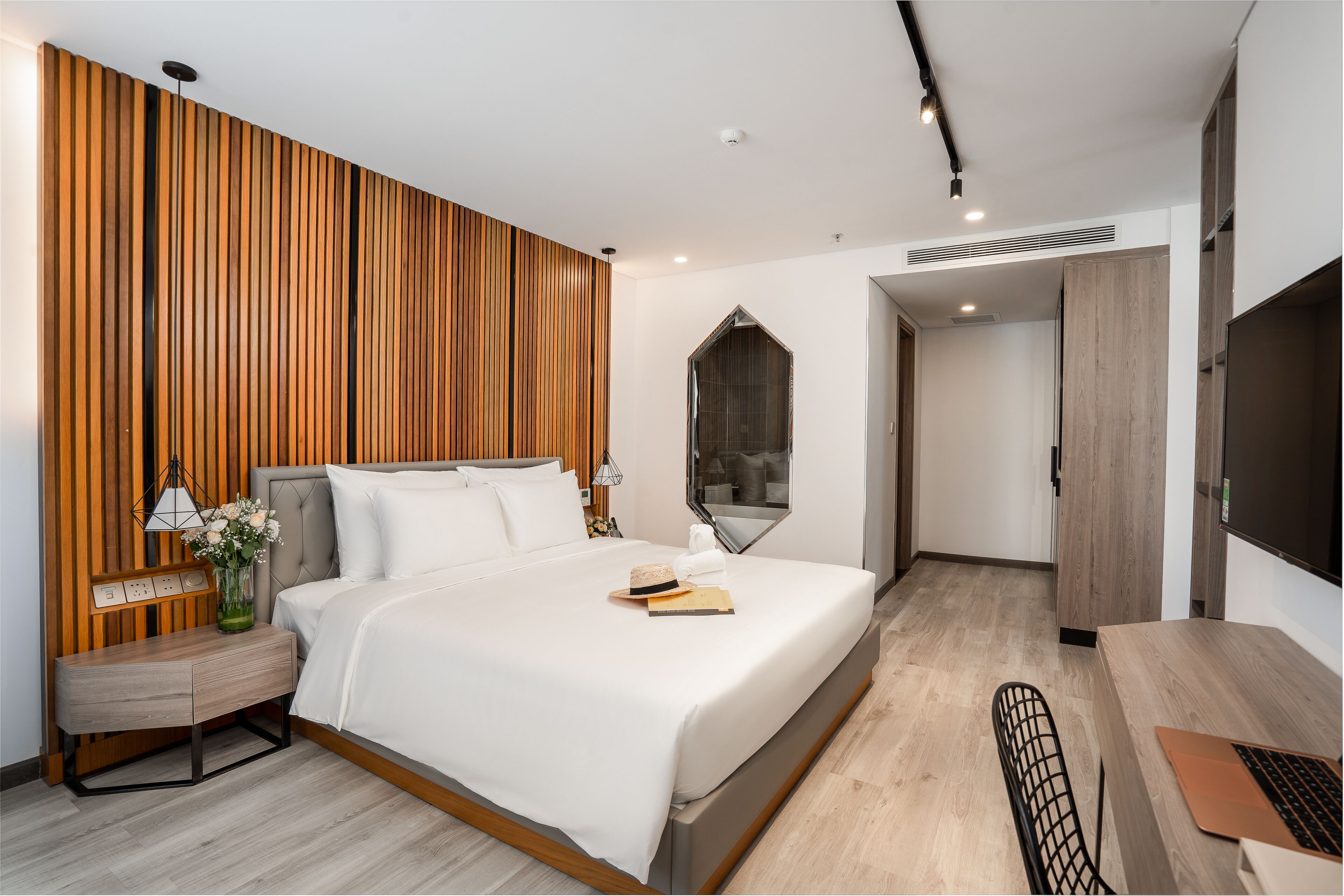 Une chambre d’hôtel moderne avec un grand lit, un bureau et un miroir.