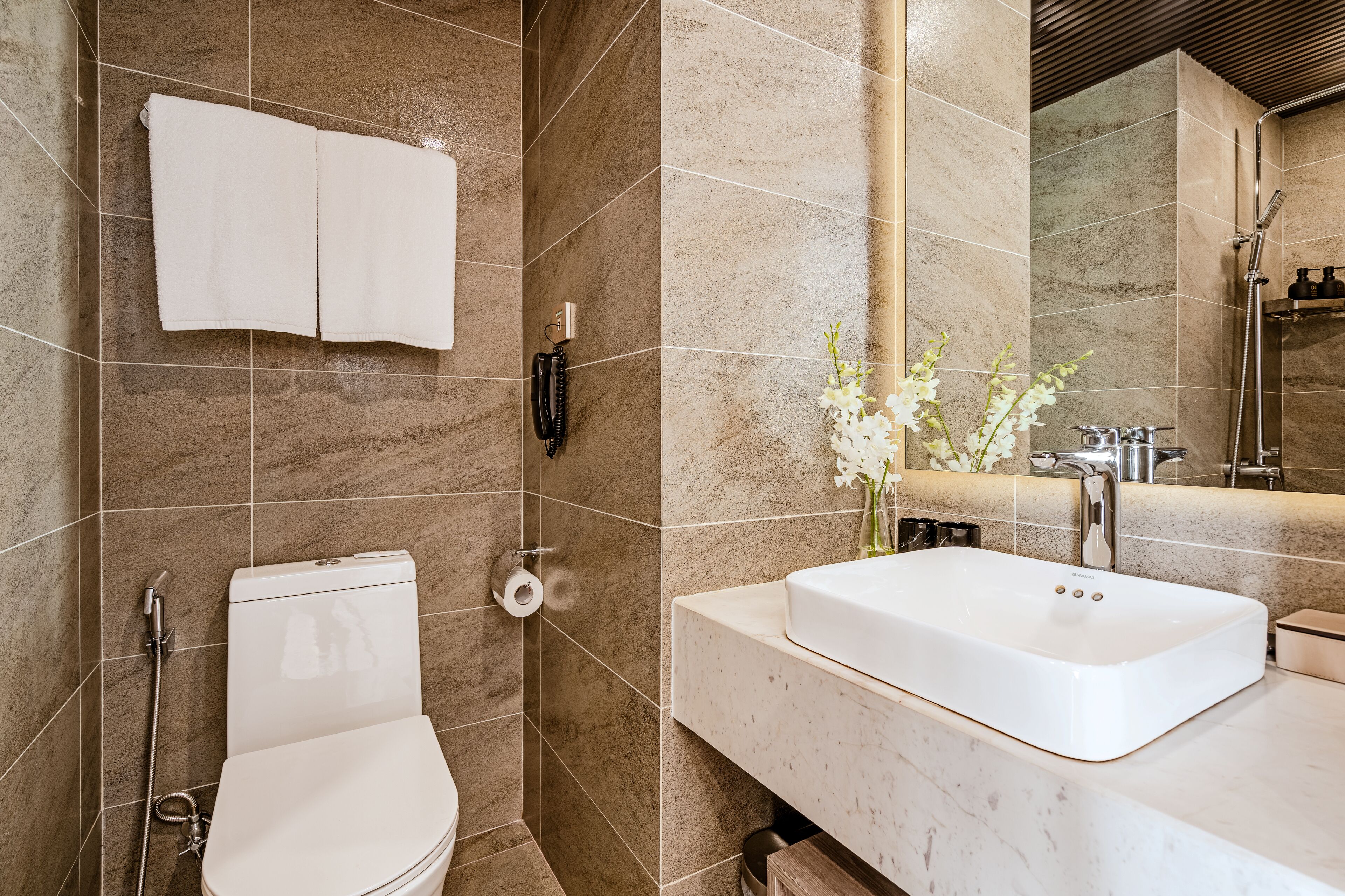 A modern bathroom with a toilet, bidet, and sink.