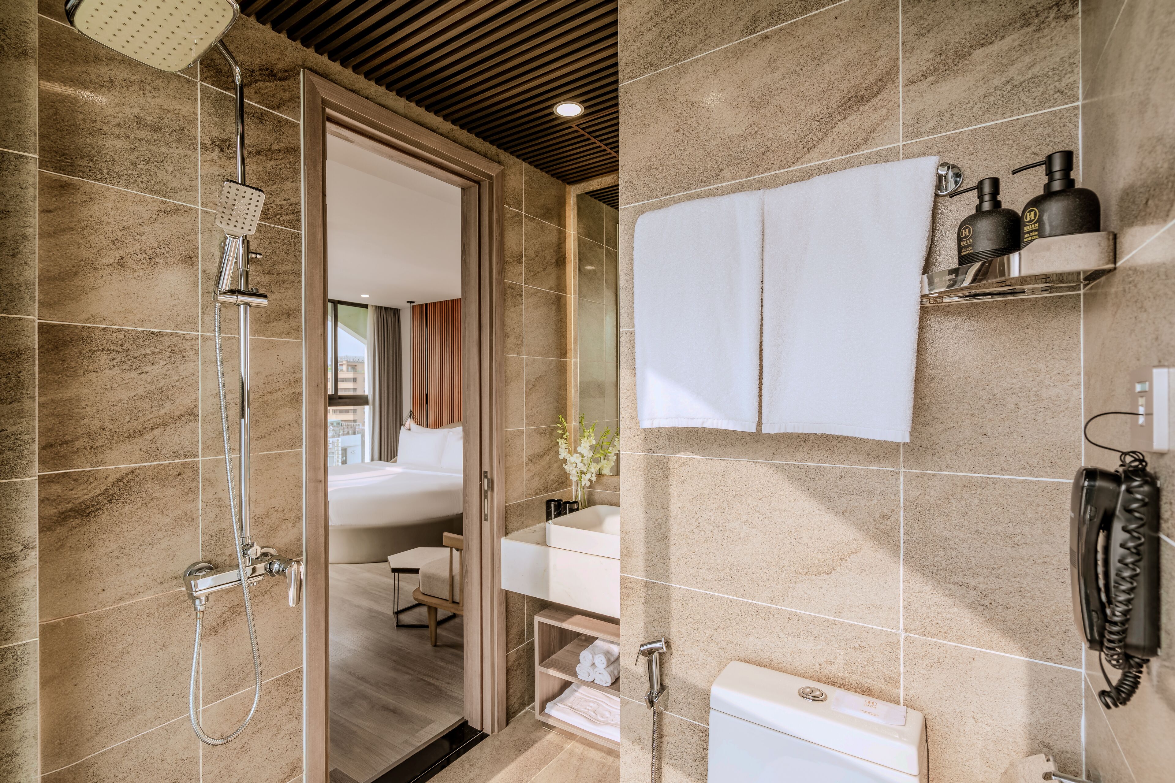 Uma casa de banho moderna com chuveiro, sanita e lavatório.