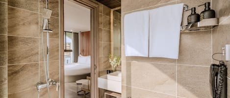 A modern bathroom with a shower, toilet, and sink.