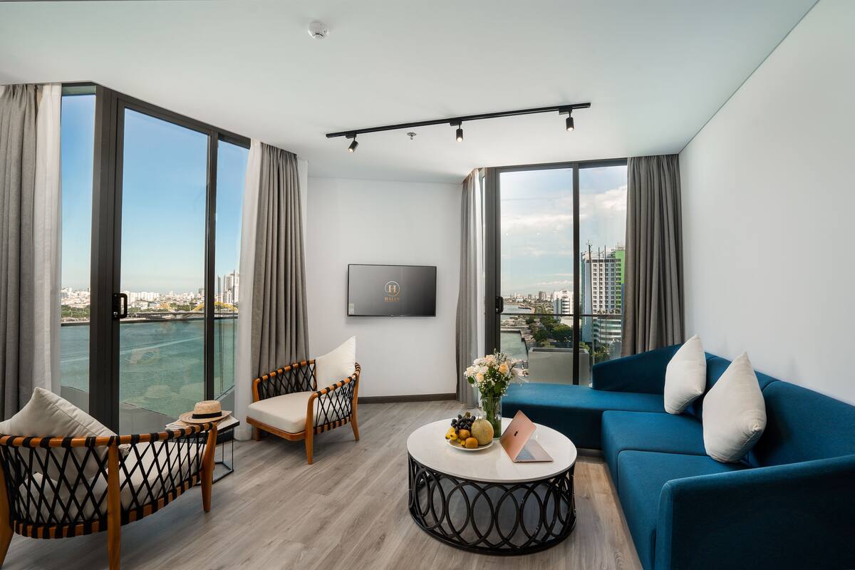 Uma sala de estar moderna com sofá, poltrona e mesa de centro redonda.