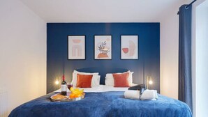 A hotel room with a large bed, a tray with breakfast items, and three framed artworks on the wall. - Beautiful Apartment • City Centre • Balcony • Free Parking • Fast WiFi • Smart TV • Yoko Property (Milton Keynes)