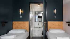 A hotel room with two beds, a wooden headboard, a sink, and a mirror. - Eklo Hotels Clermont-Ferrand City center train station (Clermont-Ferrand)