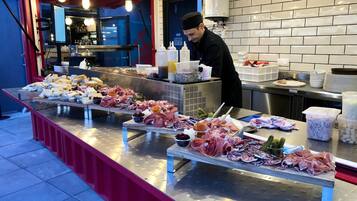 A buffet with various meats and cheeses.