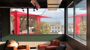 A modern interior with leather sofas, a glass table, and large windows offering a city view. - Eklo Hotels Clermont-Ferrand City center train station (Clermont-Ferrand)