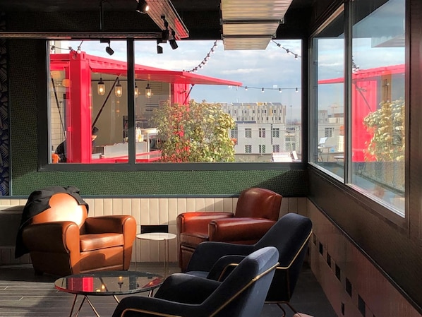 Un interior moderno con sofás de cuero, una mesa de vidrio y grandes ventanales con vistas a la ciudad.