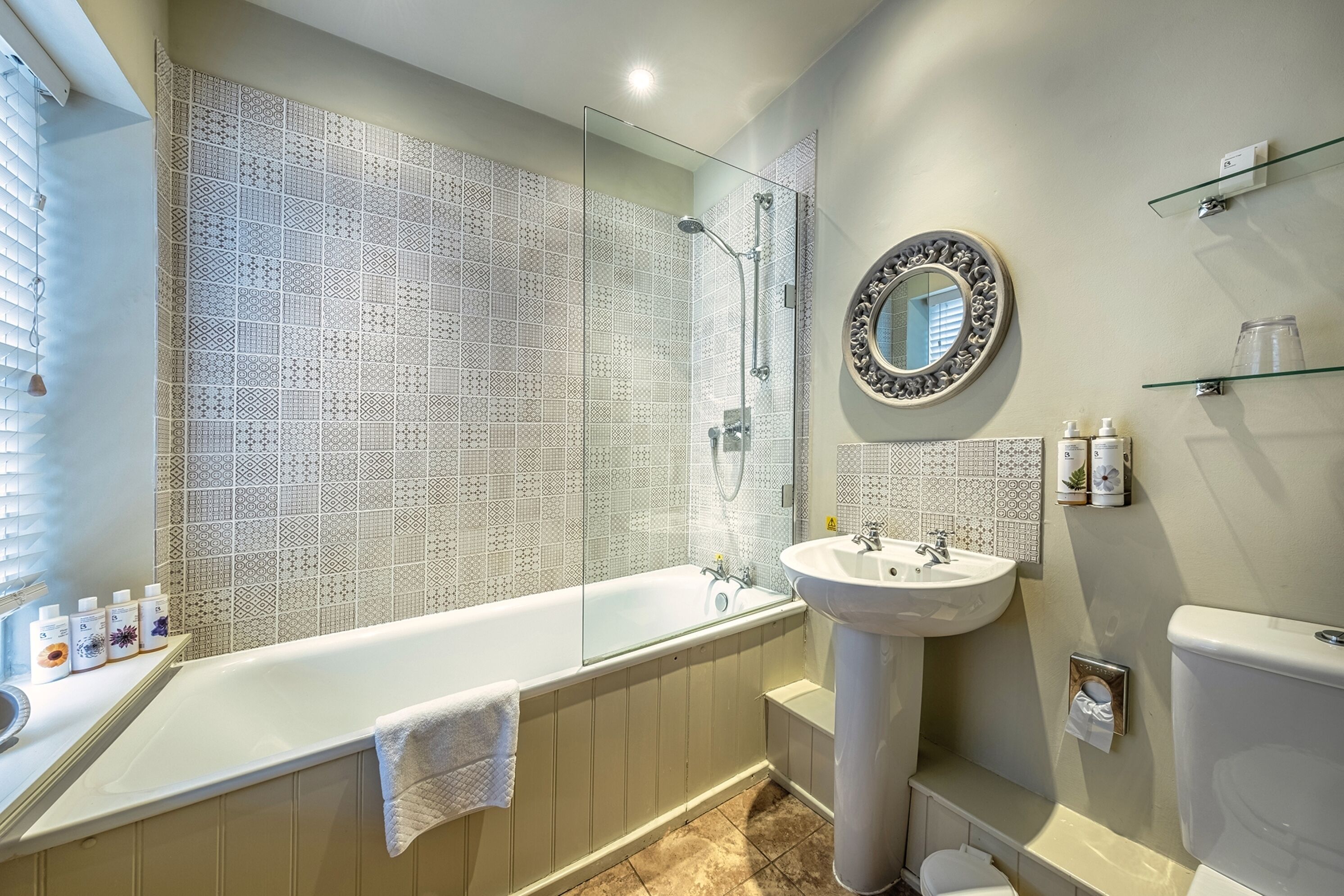A modern bathroom with a freestanding bathtub, a wall-mounted sink, and a toilet.