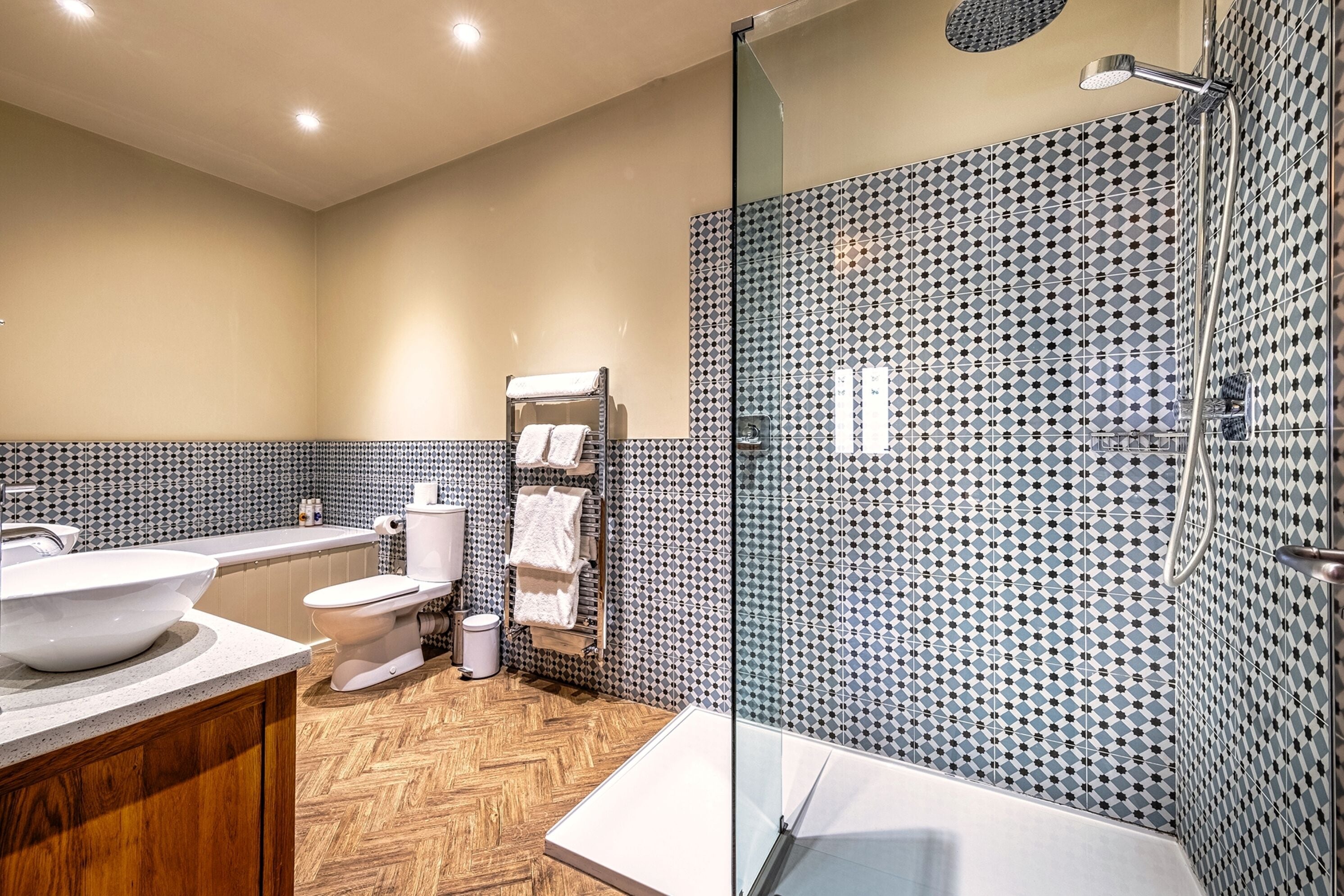 A modern bathroom with a large sink, toilet, and shower area.