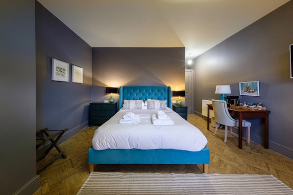 A bedroom with a large bed, a desk, and a chair. - The Globe Inn Wells (Wells-next-the-Sea)