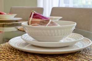 Un juego de té de cerámica blanca con un posavasos tejido.